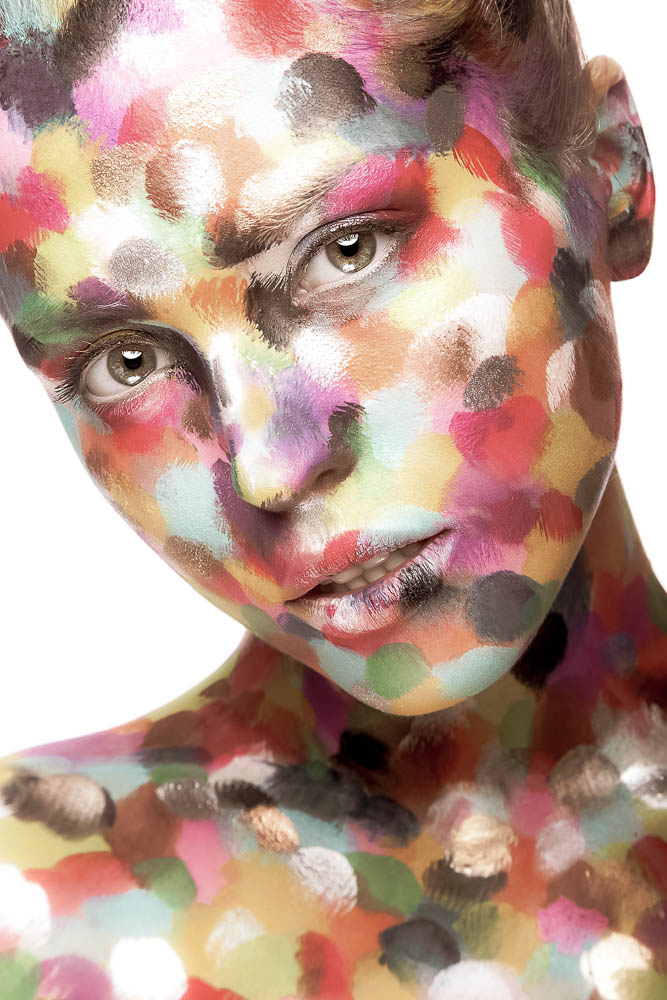 Girl with colored face painted. Art beauty image.